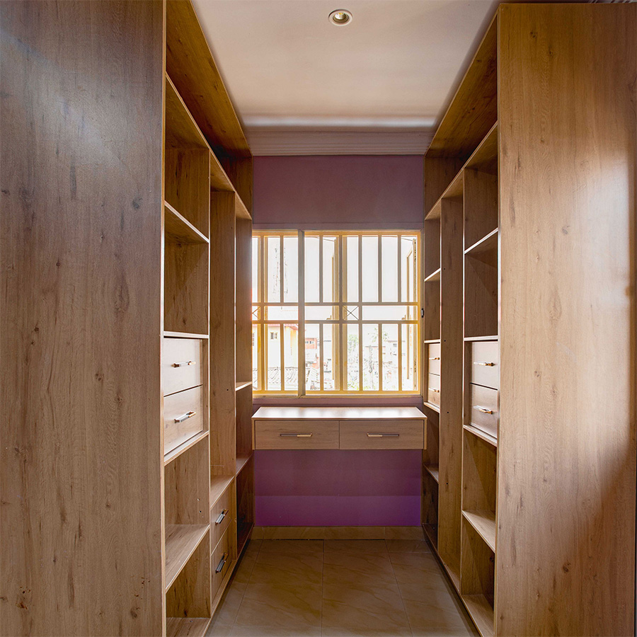 Custom walk-in wardrobe with wooden shelves and drawers in Lagos